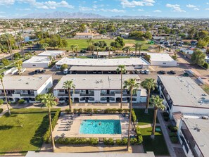 A hotel with a swimming pool, multiple parking lots, and a view of the surrounding cityscape. - Litchfield Park Getaway and Pool 2BR Condo (Litchfield Park)