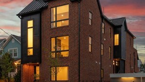 A modern two-story brick building with large windows and a flat roof. - 6 Bedrooms with Hot Tub, Rooftop, Garage + near Downtown (Nashville)