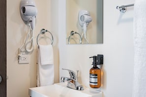 A bathroom with a hairdryer, a towel, a sink, a mirror, and a soap dispenser. - 3 bedrooms | Polanco | Relax (Ciudad de México)
