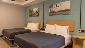 Ein Hotelzimmer mit zwei Betten, einem Deckenventilator und Bildern an den Wänden.