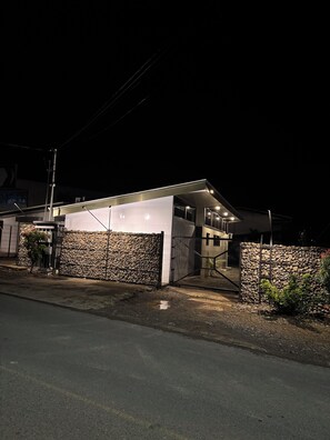 Una casa moderna con garage, muro in pietra e ingresso carrabile.