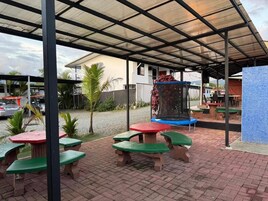 An outdoor patio area with picnic tables and a trampoline.