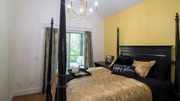 Une chambre à coucher avec un lit à baldaquin, un lustre et une fenêtre avec des rideaux.