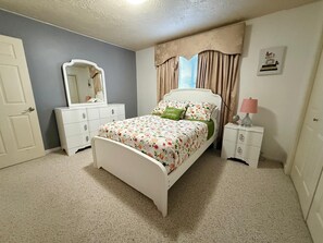 A bedroom with a bed, dresser, mirror, lamp, and curtains. - Central & Spacious 4-bedroom house in beautiful Houston with Central A/C (Houston)