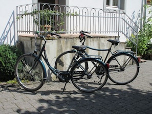 Ein Fahrrad vor einem Gebäude mit einem Metallgitter und einer Betonmauer.