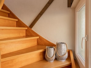 A wooden staircase with two decorative vases at the bottom.
