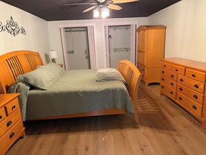 A bedroom with a bed, wooden dresser, wardrobe, and a ceiling fan. - Cozy 1-bedroom apartment in great convenient location in Marietta, GA (Marietta)