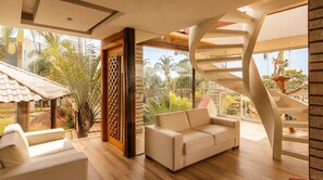 A modern interior with a spiral staircase, a sofa, and a view of the outdoors. - Casa em Condom nio com Piscina e Sinuca em Itupeva (Itupeva)