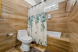 A bathroom with a toilet, shower, and bathtub.