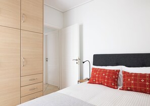 Een slaapkamer met een bed, een kledingkast en een deur.