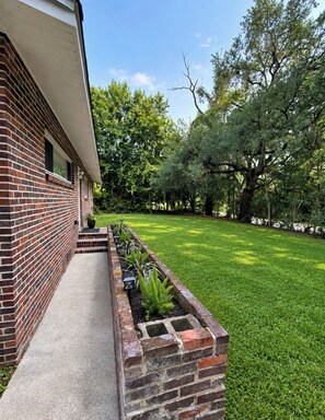 A brick building with a well-maintained lawn and trees.