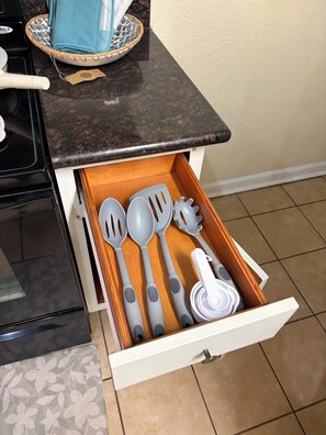 A kitchen drawer with various utensils.