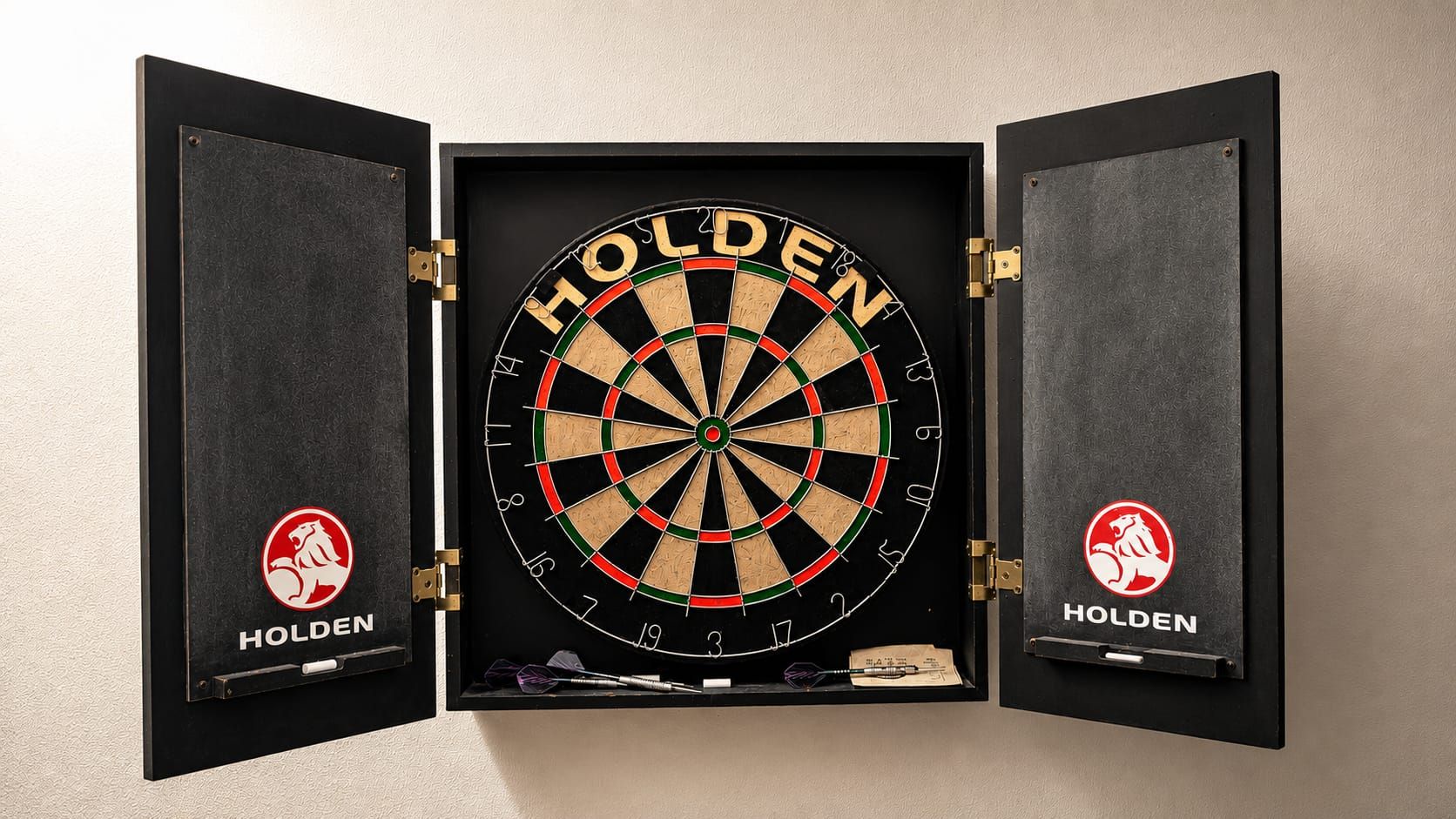 Um alvo de dardo com a marca 'HOLDEN' fixada na parede.