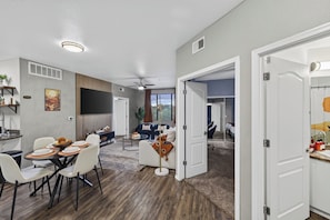 A modern living space with a dining area, seating, and a view of the outdoors. - Tranquil Escape Pool-Gym-Free Parking 1st Floor (Phoenix)