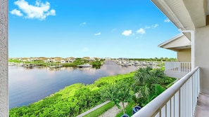 Ein Balkon mit Blick auf einen Hafen und Häuser gegenüber ruhigem Wasser.
