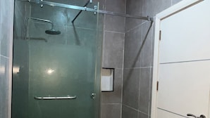 A shower enclosure with a glass door, a showerhead, and a towel rack. - 4 Bed Luxury Town House (Lagos)