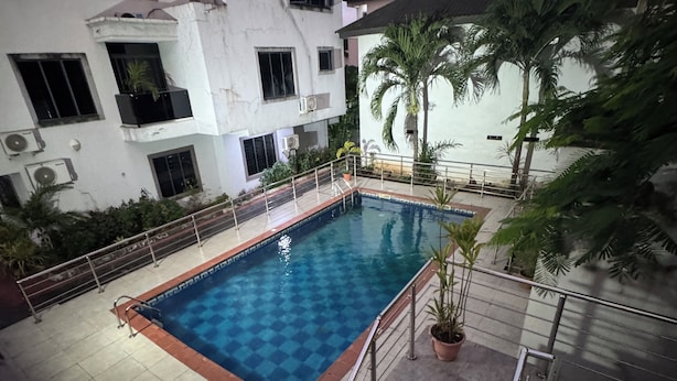 A swimming pool with a checkered pattern, surrounded by a metal railing and stairs leading down to the pool. - 4 Bed Luxury Town House (Lagos)
