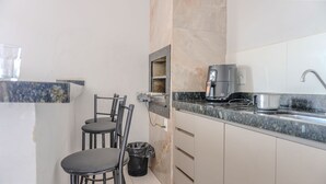 Eine kleine Küchenzeile mit Kaffeemaschine, Spüle und einer Arbeitsplatte.