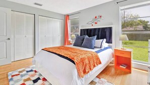 A bedroom with a bed, a nightstand, a window with a view, and a closet. - Cozy home New Port Richey (New Port Richey)