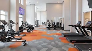 Una palestra con tapis roulant, cyclette e macchinari per pesi.