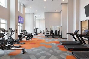 Een sportschool met loopbanden, hometrainers en krachtapparaten.