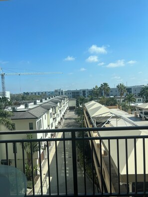 A residential area with multiple buildings, a clear sky, and a construction crane in the distance. - Bright 2-bedroom apartment with AC in brilliant Sarasota City Center ! (Sarasota)