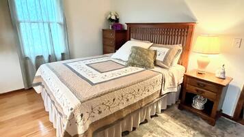 Une chambre à coucher avec un lit, une table de chevet, une lampe et une commode.