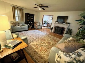 A living room with a sofa, a coffee table, a fireplace, and a television.