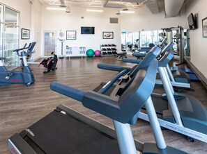 A gym with treadmills, exercise balls, and dumbbells. - Accessible Queen Studio w/ Free Hot Breakfast (Saskatoon)