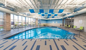An indoor swimming pool with clear water, marked depth lines, and safety signs. - Accessible Queen Studio w/ Free Hot Breakfast (Saskatoon)