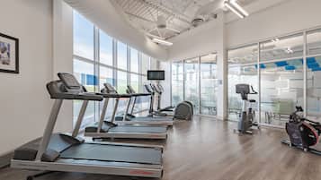A gym with treadmills, elliptical machines, and a stationary bike.