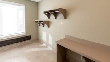 A room with a large window, a desk, and wall-mounted shelves.
