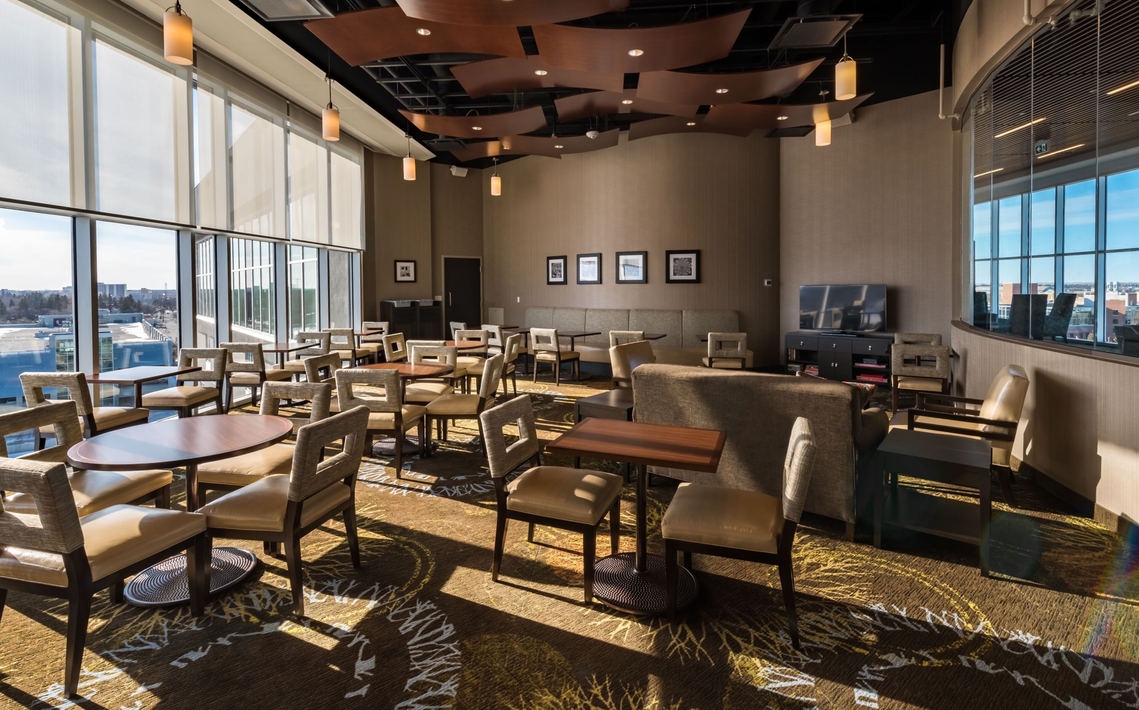 A spacious hotel lobby with high ceilings, large windows, and a variety of seating arrangements.