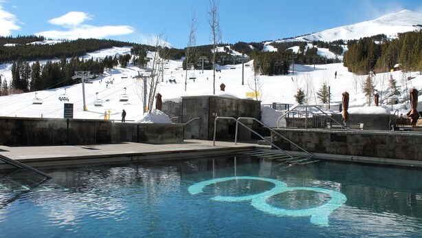 Una piscina con un telesilla al fondo.