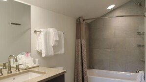 Un baño con lavamanos, espejo y bañera.