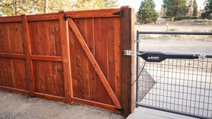 A wooden gate with a metal gate and a black sign that reads 'GHOST CONTROLS.' - Bend river park retreat (Bend)