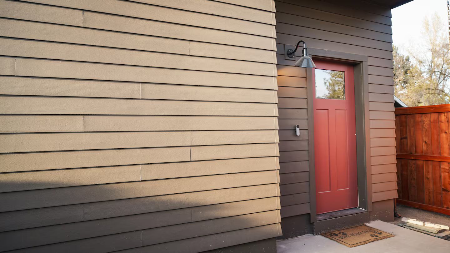 A house with a red door, a mailbox, and a porch light.