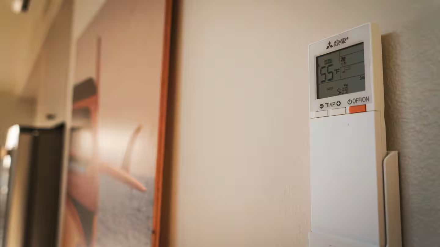 A thermostat with a digital display indicating a temperature of 55°F and a time of 5:29.