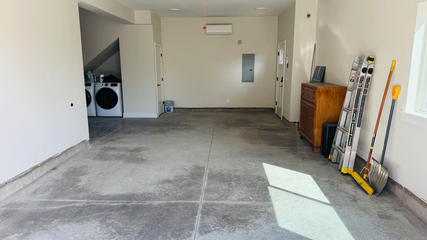 A laundry room with a washing machine, dryer, and a utility cabinet.