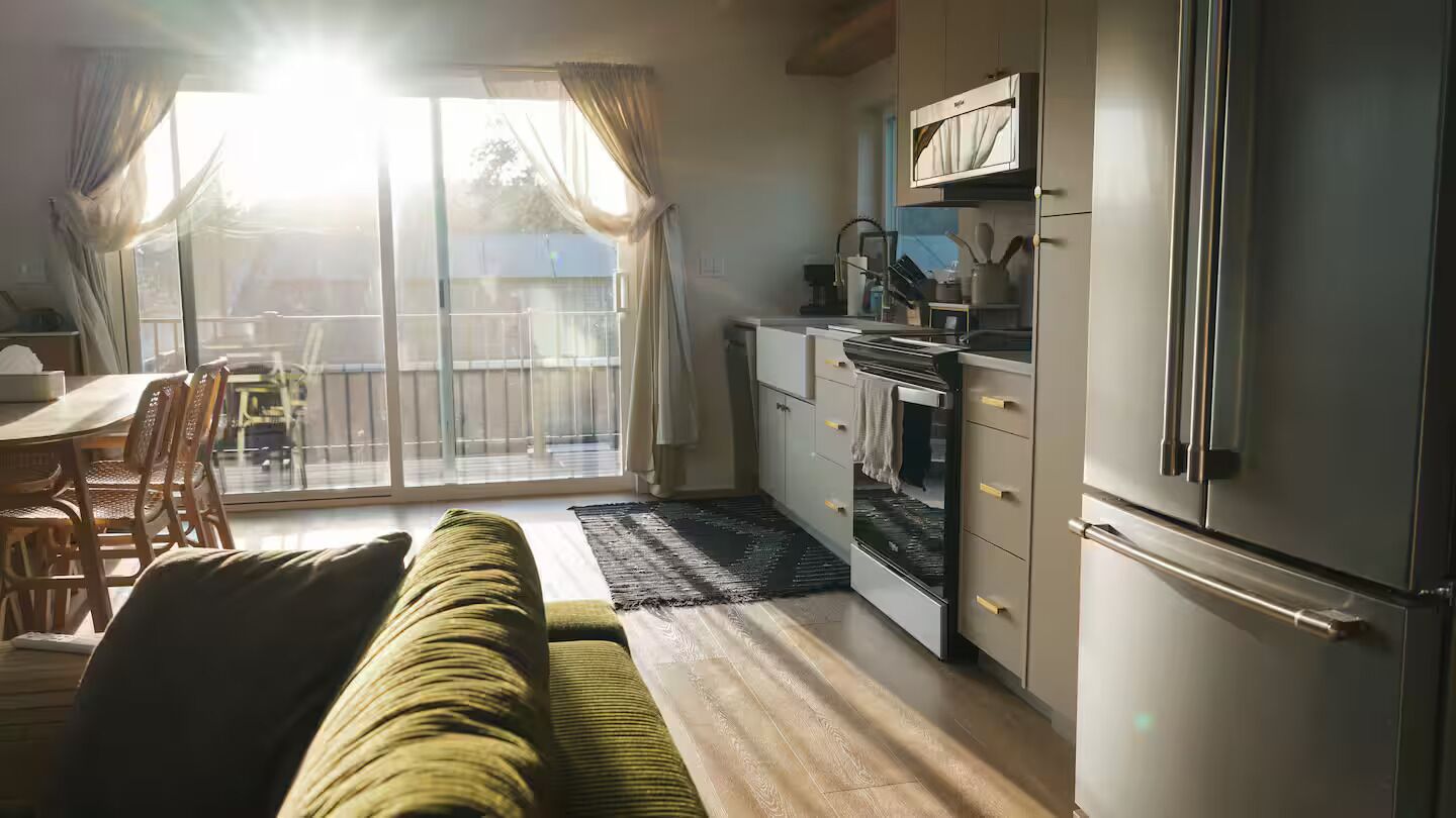 A compact living space with a sofa, dining table, and kitchenette.