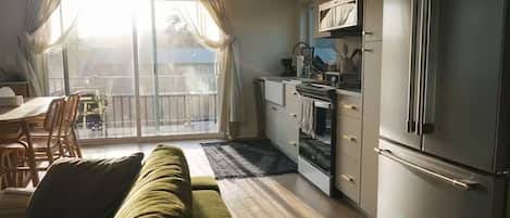 A compact living space with a sofa, dining table, and kitchenette.