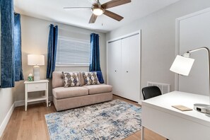 A bedroom with a bed, bedside table, lamp, and a ceiling fan. - Cozy 2-bedroom house in charming Tampa with AC (Tampa)