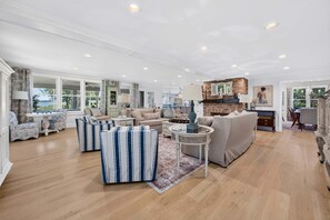 A spacious living room with a fireplace, a dining area, and a view of the outdoors. - La Laval at Winyah Bay A Luxury Waterfront Estate with Pool (Georgetown)