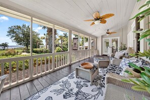 A covered porch with wicker furniture, a patterned rug, and ceiling fans. - La Laval at Winyah Bay A Luxury Waterfront Estate with Pool (Georgetown)