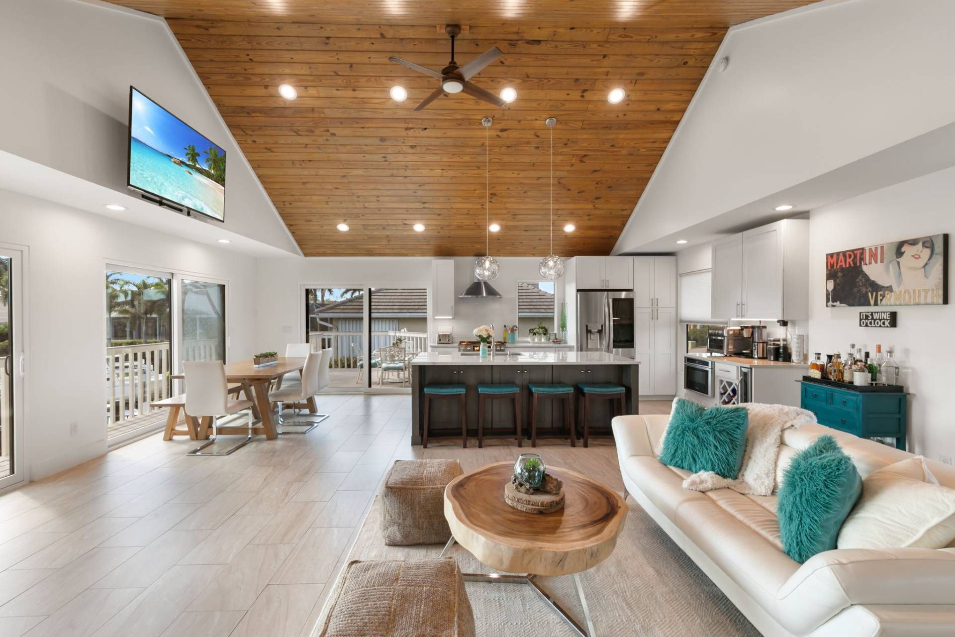 Una cocina moderna con una isla central, un comedor con vistas y una sala de estar con sofá y mesa de centro.