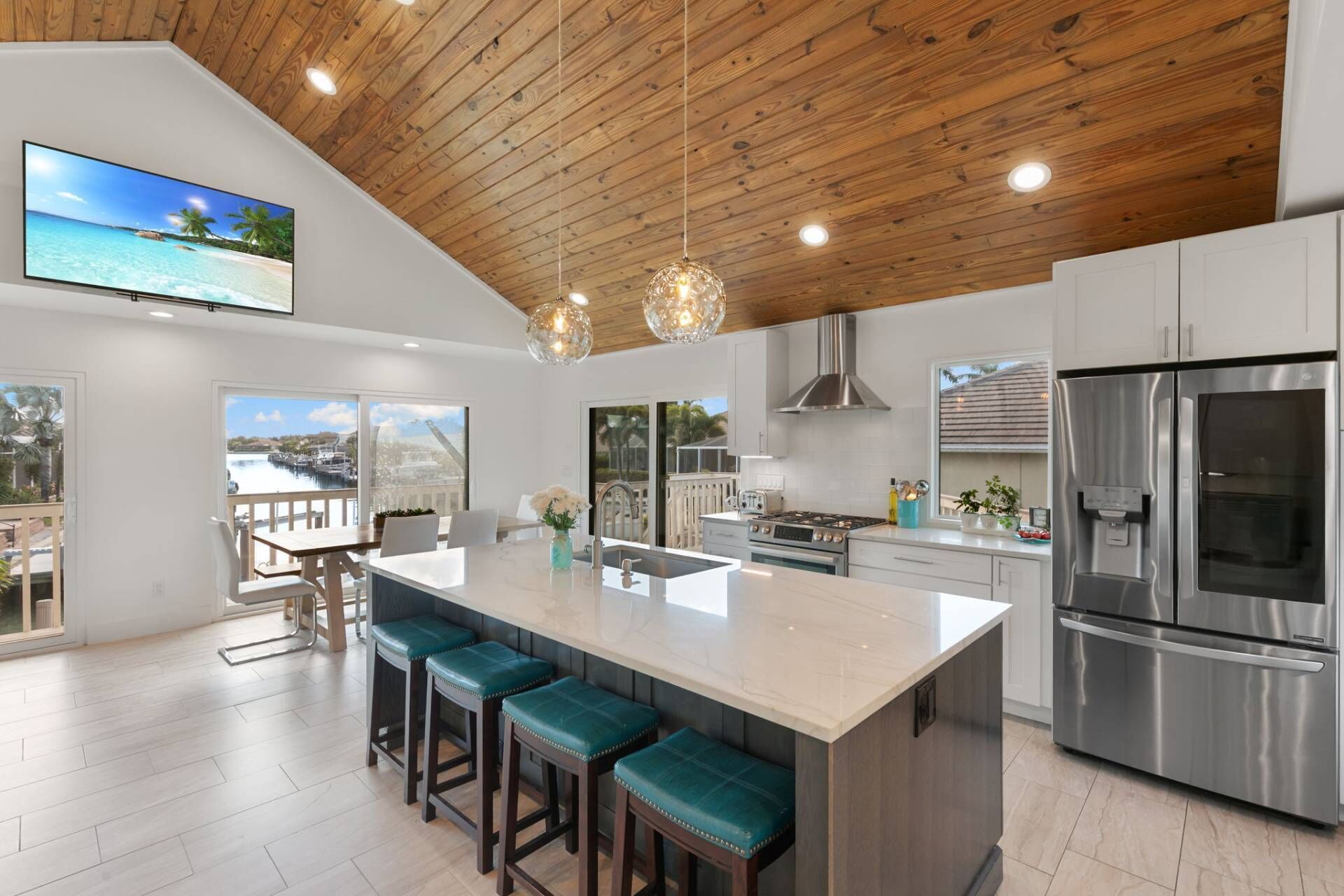 A modern kitchen with a large island, stainless steel appliances, and a view of a waterfront.