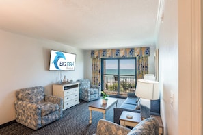 A hotel room with a balcony, a TV mounted on the wall, and a view of the sea. - Coastal Paradise Feels with Breathtaking Views (Myrtle Beach)