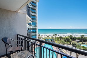 A balcony with a view of a beach and a pool area. - Coastal Paradise Feels with Breathtaking Views (Myrtle Beach)