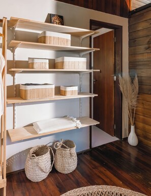 A wooden shelving unit with storage baskets and a vase with pampas grass. - Araçá House. Exclusive lagoon retreat accessible by boat. (Florianópolis)