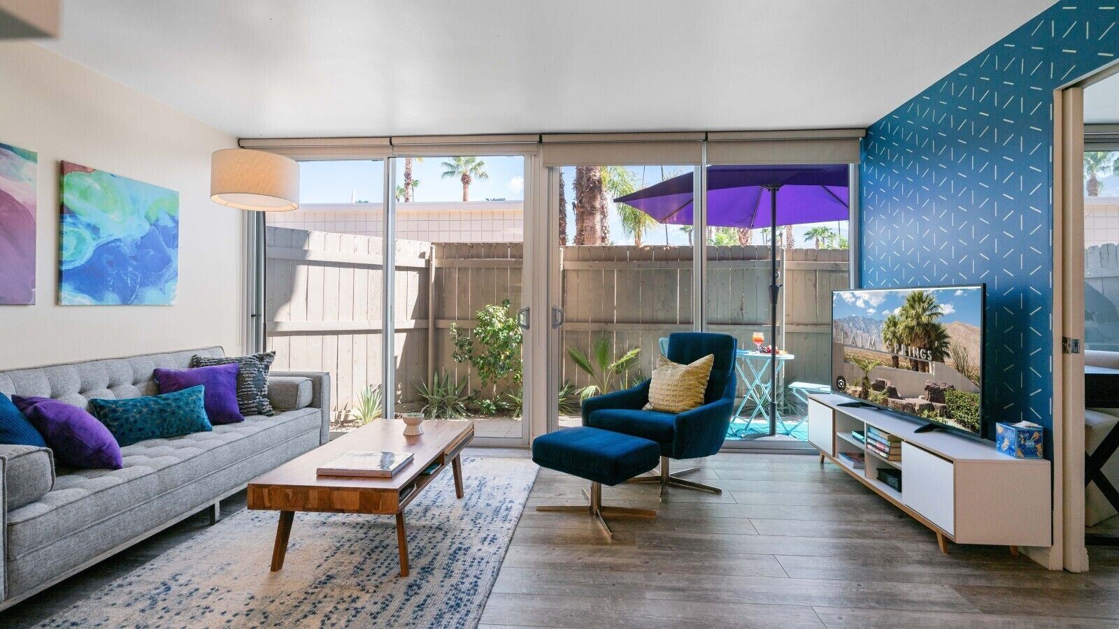 A living room with a sofa, coffee table, blue armchair, and TV.